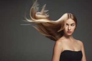 beautiful model with long smooth flying blonde hair isolated dark grey studio background young caucasian model with well kept skin hair blowing air 155003 21877
