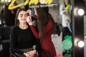 two girls are doing make up front big professional mirror 231208 3557